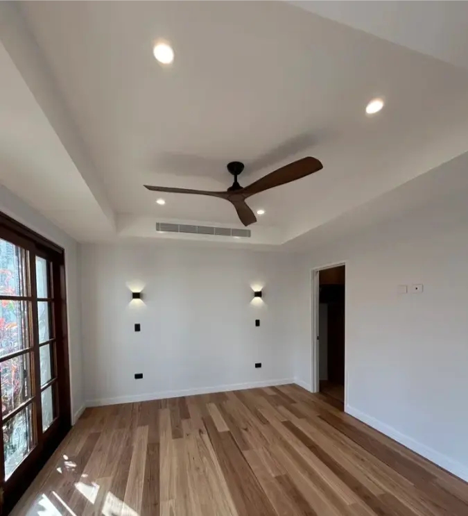Licensed electrician installing a ceiling fan on the Gold Coast